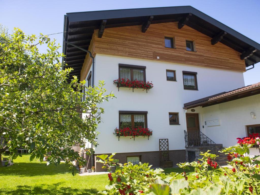 una grande casa bianca con fiori alle finestre di Bei Steiner a Wörgl