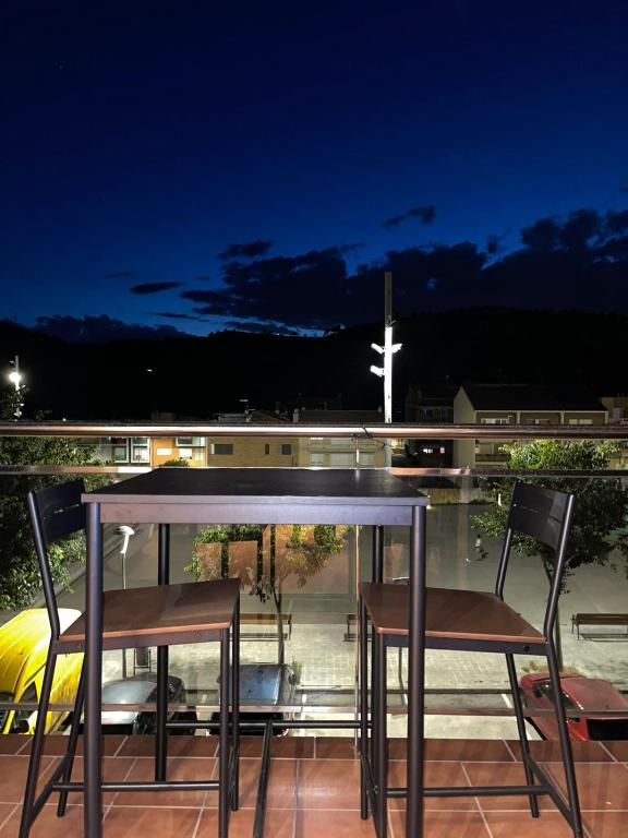 a table and two chairs on a balcony with a cross at DUPLEX LUMINOSO Y TRANQUILo in El Pont de Vilumara