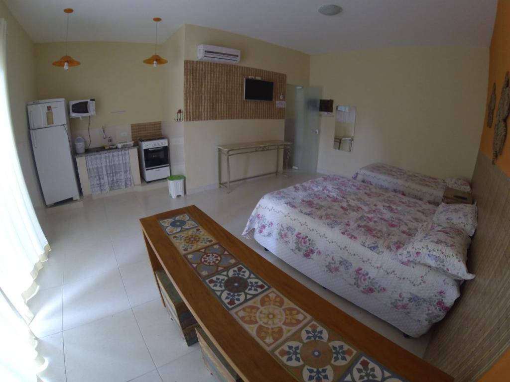 Il comprend une petite chambre avec un lit et une cuisine. dans l'établissement Casa do Monge Apartments, à Ilhabela