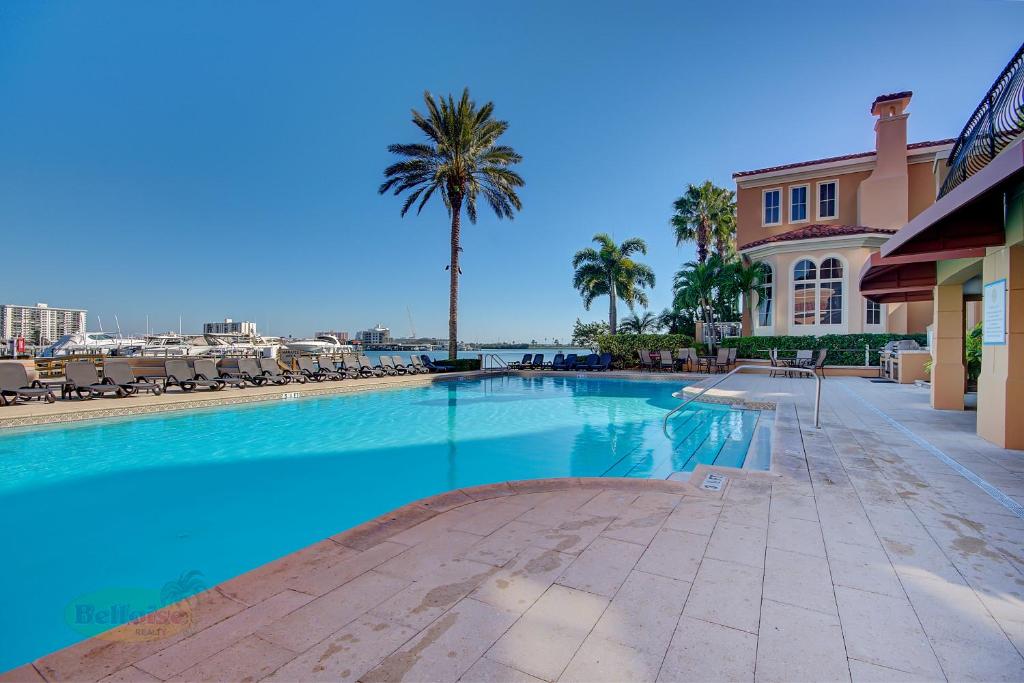 een groot zwembad met palmbomen en een gebouw bij Belle Harbor Suite 71 - Monthly Rental in Clearwater Beach