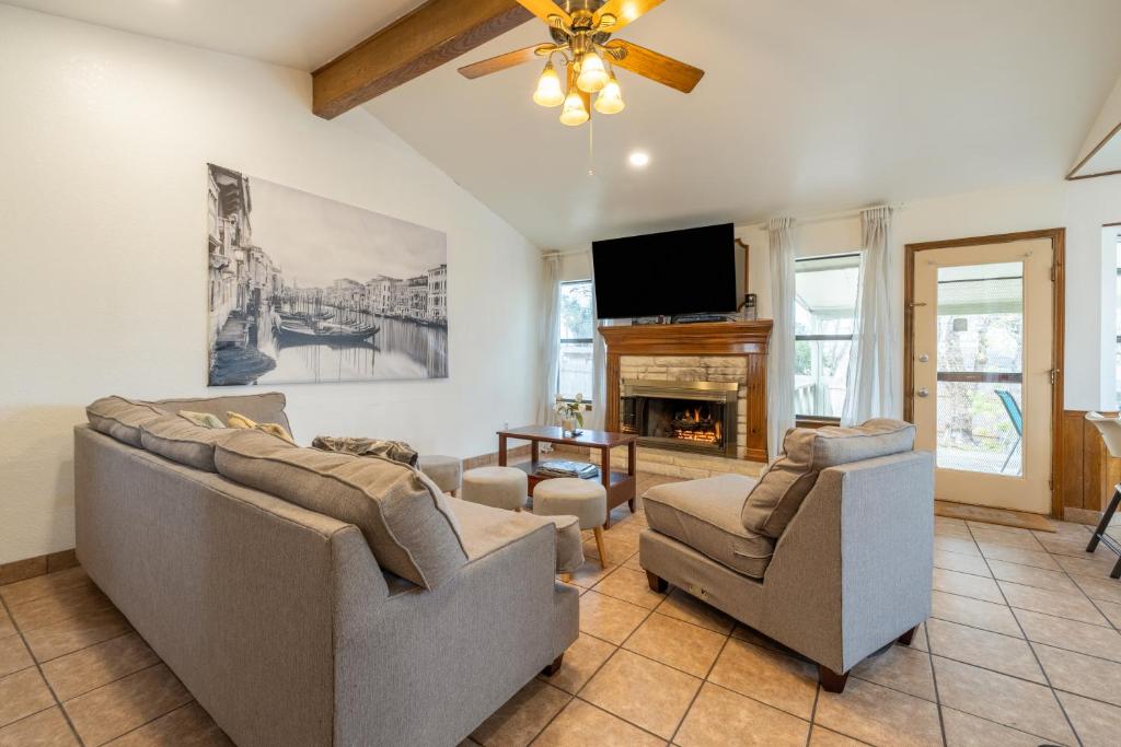 a living room with two couches and a flat screen tv at Private Retreat Shady Oak Backyard, PetFriendly in Round Rock