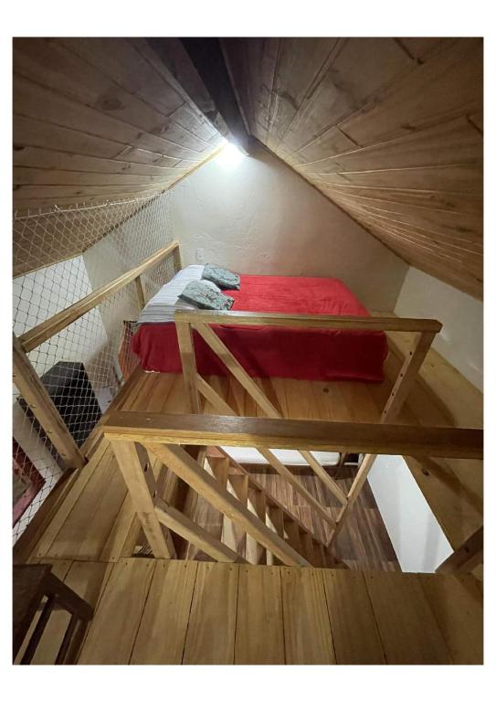 a bed on a wooden platform in a room at Pousada Montanha Mágica in São Thomé das Letras