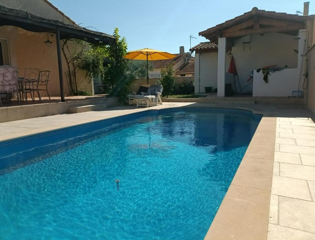 une piscine avec de l'eau bleue dans une cour dans l'établissement Belle Villa piscine 4 personnes, à Vestric-et-Candiac