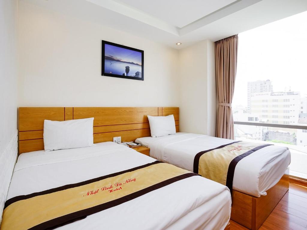 Postel nebo postele na pokoji v ubytování Nhat Linh Hotel & Suites Da Nang