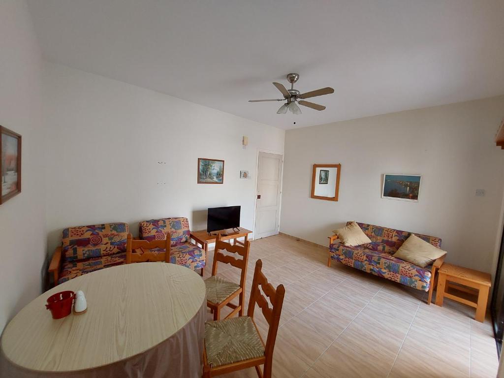 a living room with a table and a couch at Kapparis Apartment in Paralimni