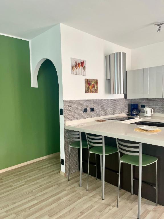 a kitchen with a white counter and green walls at Casa vacanze Sissi in Arco