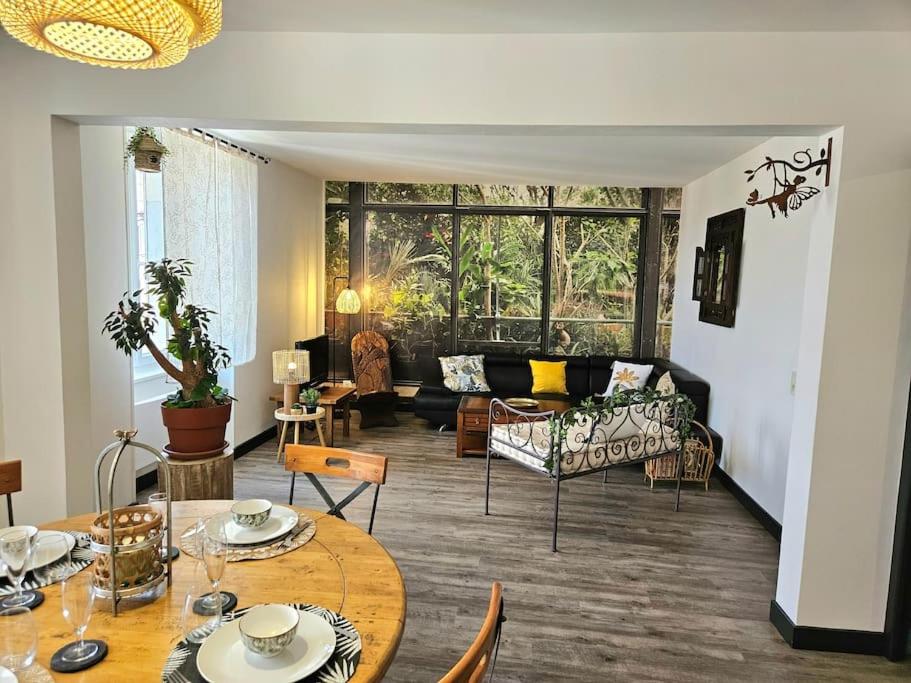 a living room with a table and a couch at Appartement Le Jardin Imaginaire in Champagnole