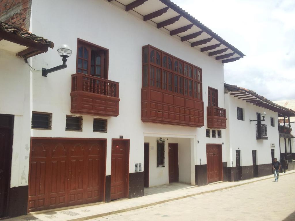 - un bâtiment blanc avec des portes et des fenêtres marron dans l'établissement Casa Hospedaje Teresita, à Chachapoyas