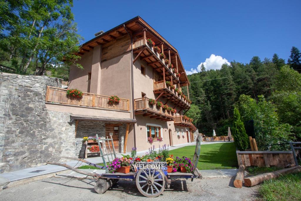 a building with a flower cart in front of it at Grande Cote Room and Breakfast in Cesana Torinese