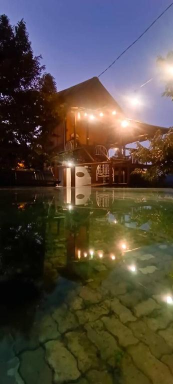 una casa con un riflesso nell'acqua di notte di BUKIT LIMAU REST HOUSE a Taiping