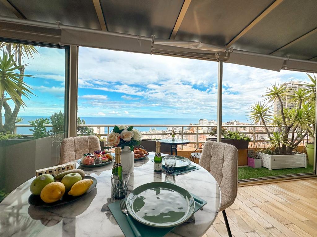 PANORAMIC MONACO VIEW, BnbRickeys في بوسولاي: غرفة طعام مع طاولة وإطلالة على المحيط