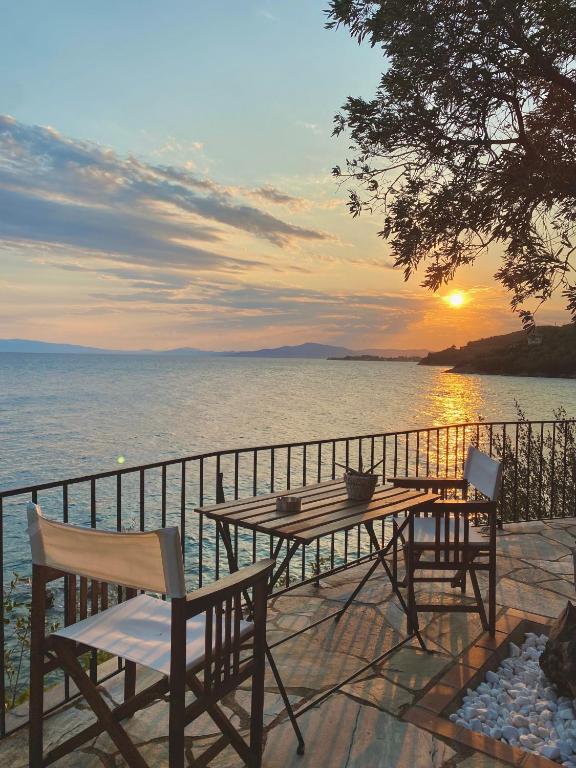 a table and chairs on a balcony with the ocean at Sunset of Pelion in Kato Gatzea