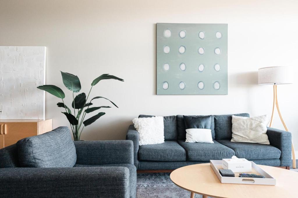 a living room with a blue couch and a table at New Spacious Modern Loft - Center of LoHi in Denver