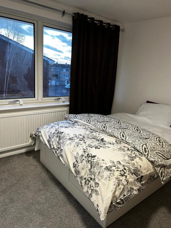 Un dormitorio con una cama frente a una ventana. en Elm Park Home with Garden & Parking, en Hornchurch