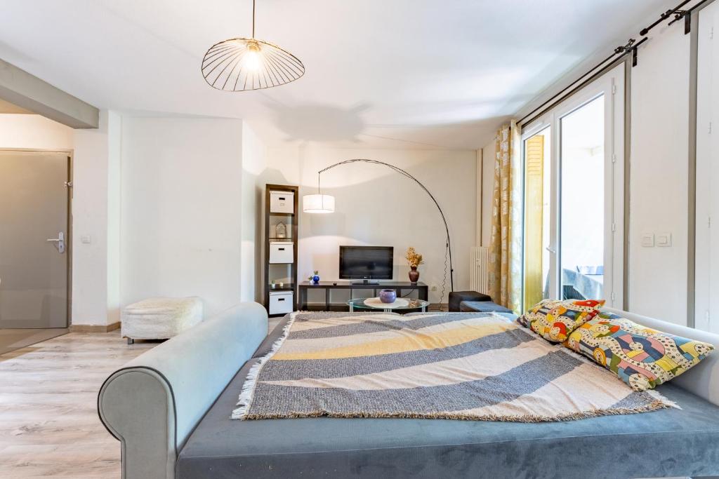 une chambre avec un lit et une grande fenêtre dans l'établissement Le Jean Rieux Place Dupuy Halle aux grains, à Toulouse