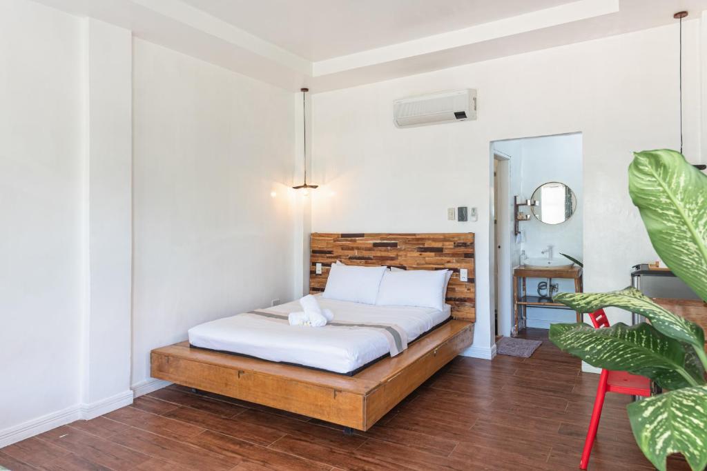 a bedroom with a bed with a wooden headboard at YAMA APARTMENTS - Private Beachfront in General Luna