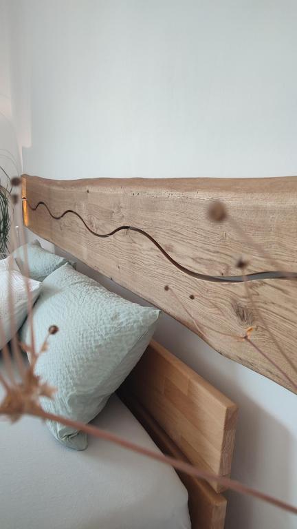a wooden shelf with two pillows on a bed at Zimmer im Herzen Gößweinsteins in Gößweinstein