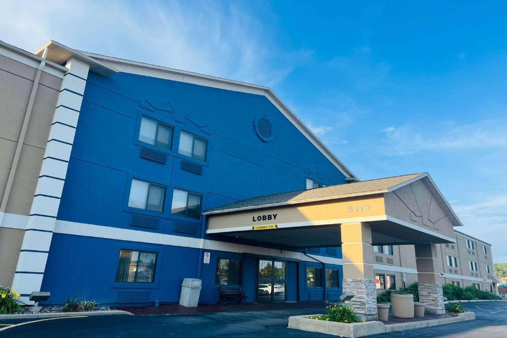 a blue building with a sign that reads lucky inn at AmericInn by Wyndham Glendale Milwaukee in Glendale