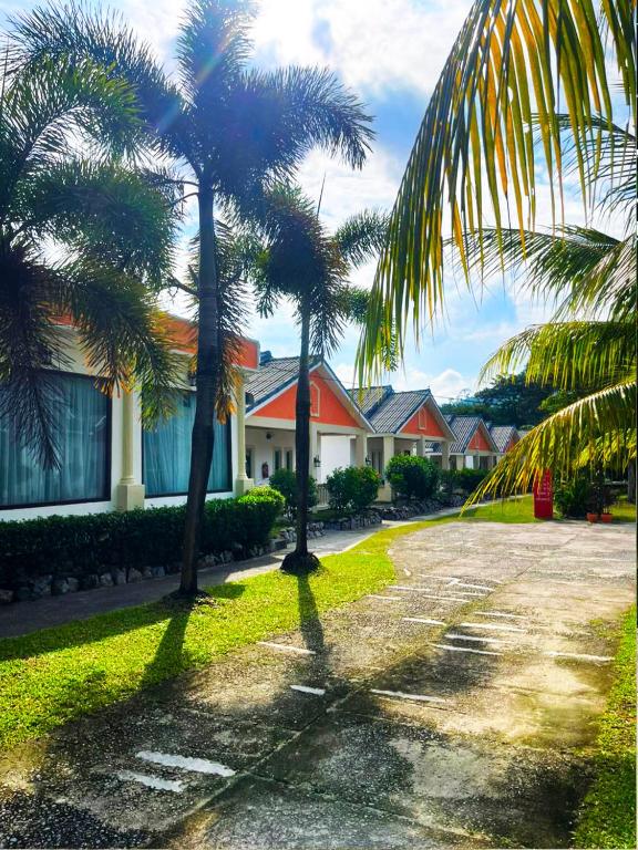 two palm trees in front of a house at Dreamz Village in Tanjung Rhu