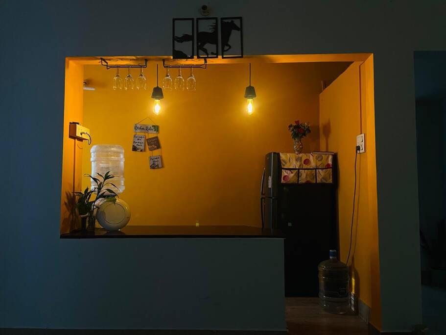 a kitchen with a yellow wall and a refrigerator at Urban loft cozy 1bhk Homestay in Guwahati