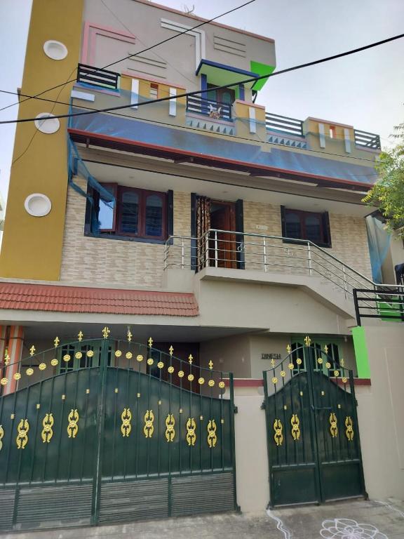 a house with a green gate in front of it at Honeycomb Homestay Ground Floor in Palni