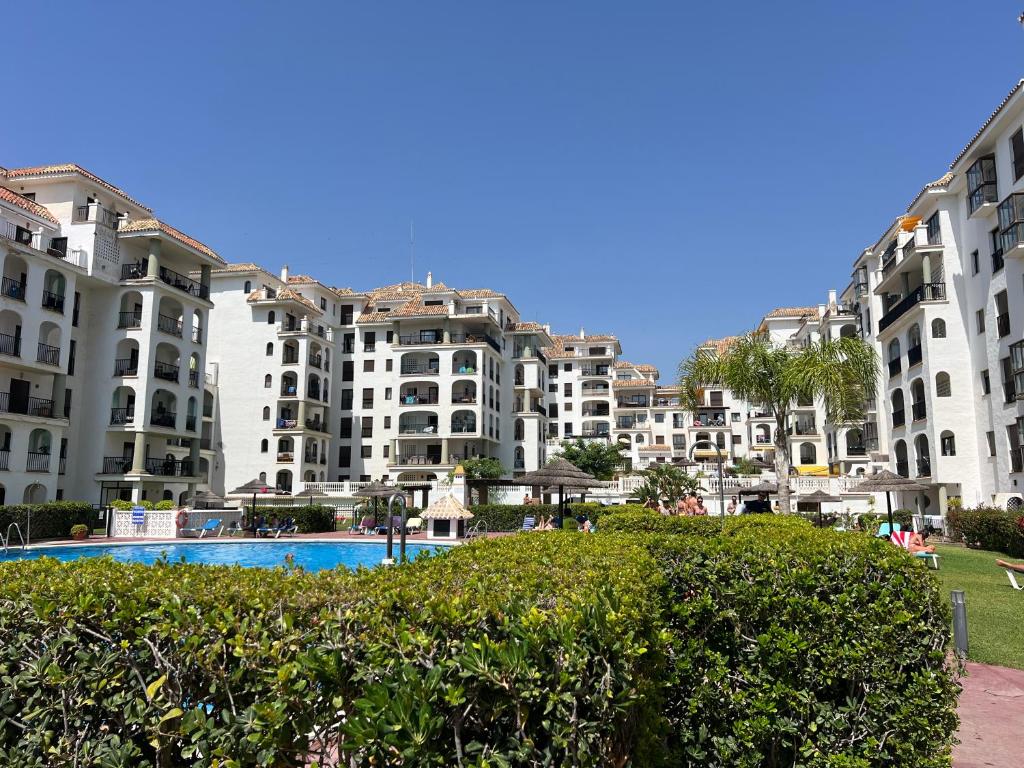 a group of large apartment buildings with a pool at Puerto De La Duquesa in Manilva