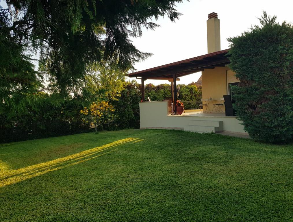 a house with a yellow line in a yard at ELENI'S HOUSE FOR VACATION in Nea Plagia