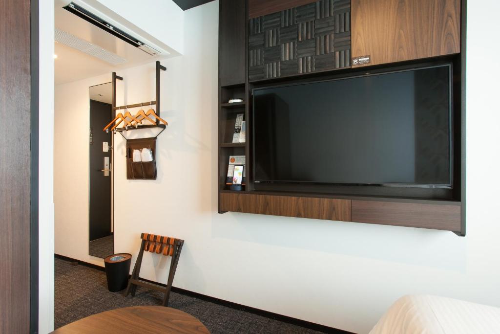 a large flat screen tv hanging on a wall at Henn na Hotel Tokyo Akasaka in Tokyo