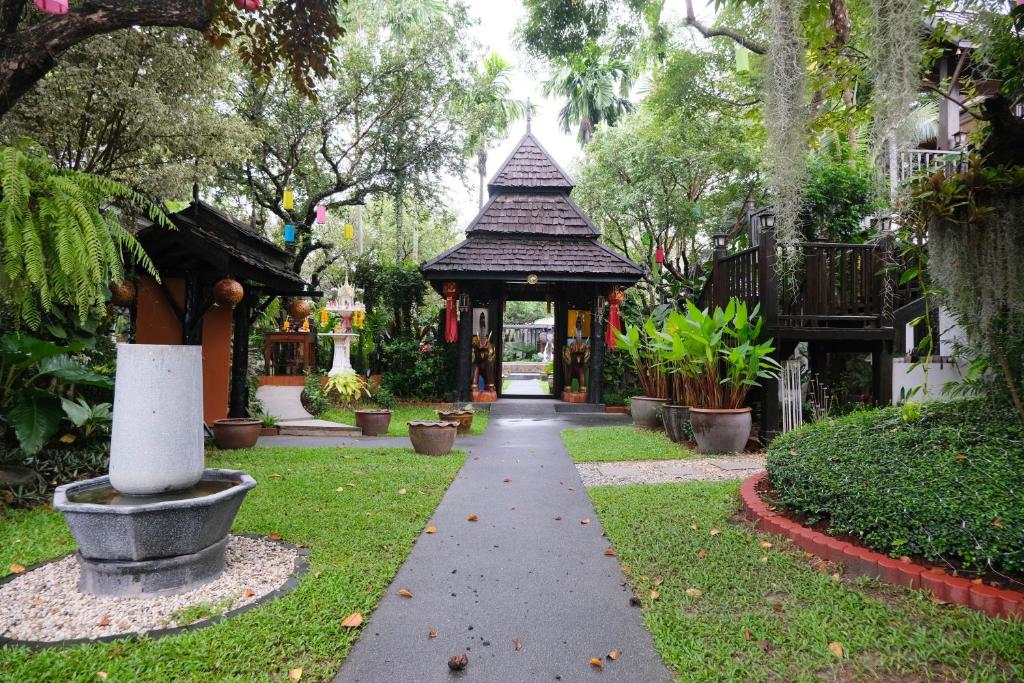 a walkway in a garden with a gazebo at Vimarn Kaew Village and Resort in Chiang Mai