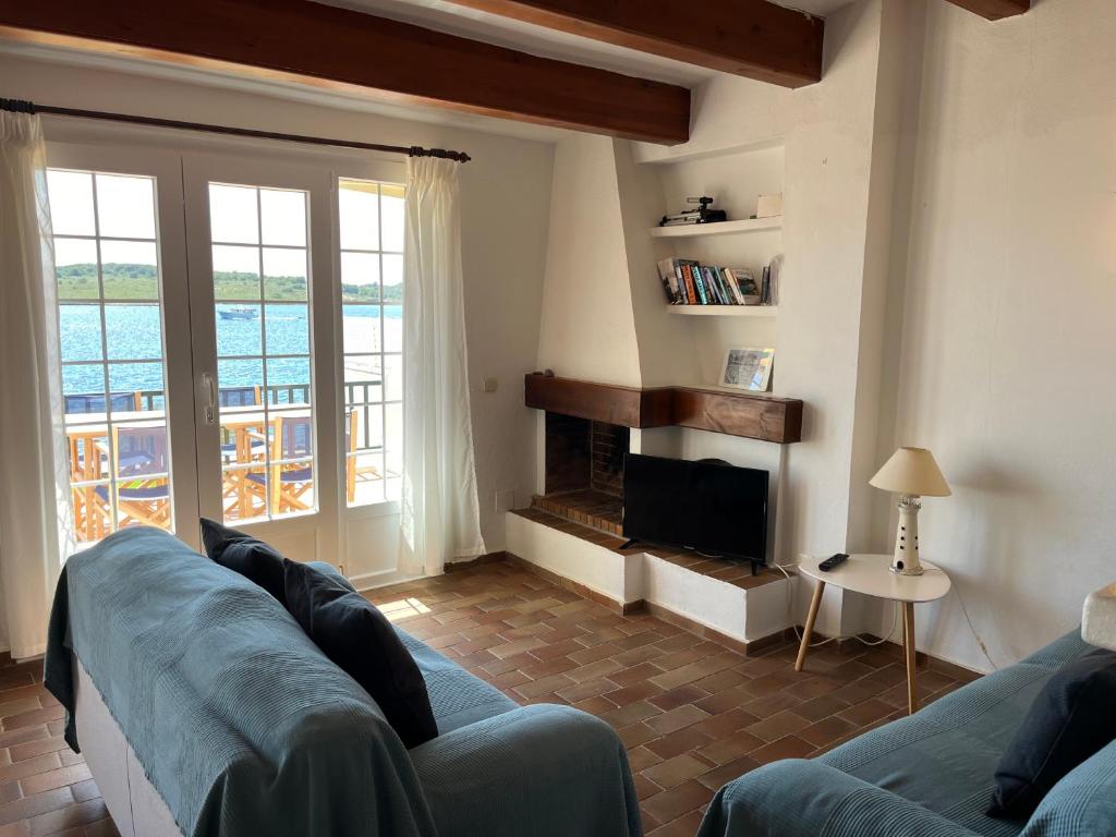salon z kanapą i kominkiem w obiekcie Es CASTELL 2 7 by SOM Menorca w mieście Fornells