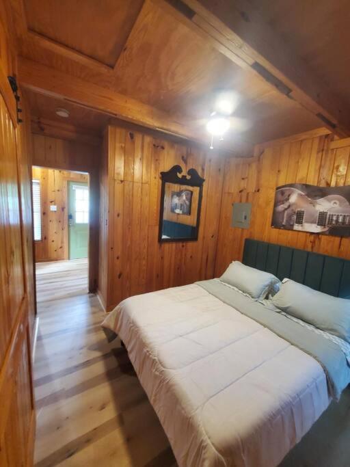 a bedroom with a large bed in a wooden wall at 109 Vinewood Cabin-1 Bedroom in Brewton