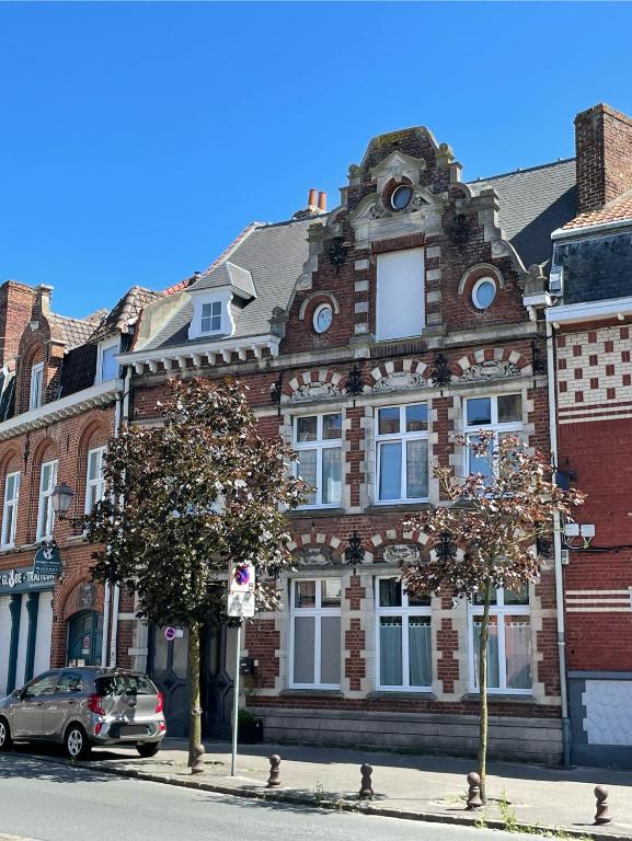 un bâtiment en briques avec une voiture garée devant dans l'établissement Studio Belle Époque, à Bailleul