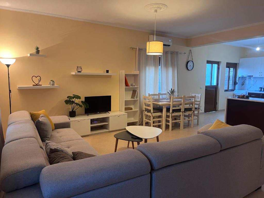 a living room with a couch and a dining room at Andrew's place in Metogjashta