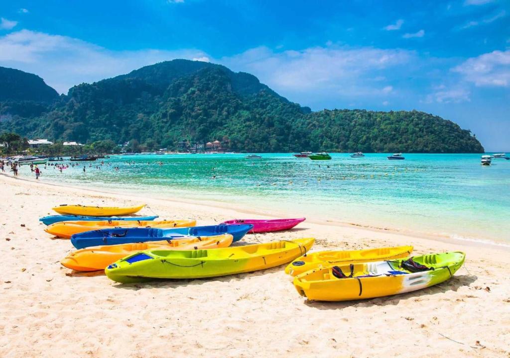 un gruppo di barche sedute sulla spiaggia di Easy Hostel a Phi Phi Don