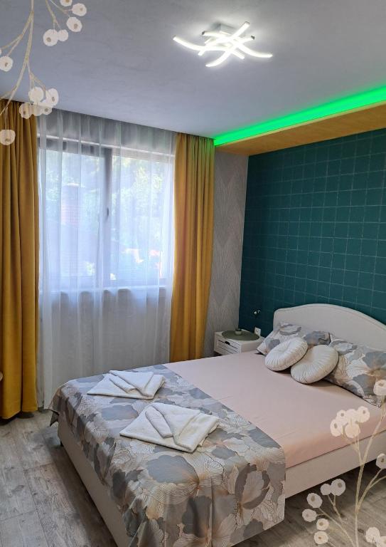 萨帕雷瓦巴尼亚Къща за гости Мурите的带床和绿墙的卧室