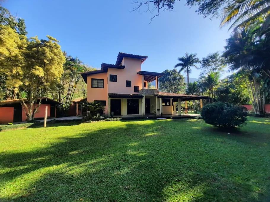 a house with a large lawn in front of it at Casa de maresias in São Sebastião