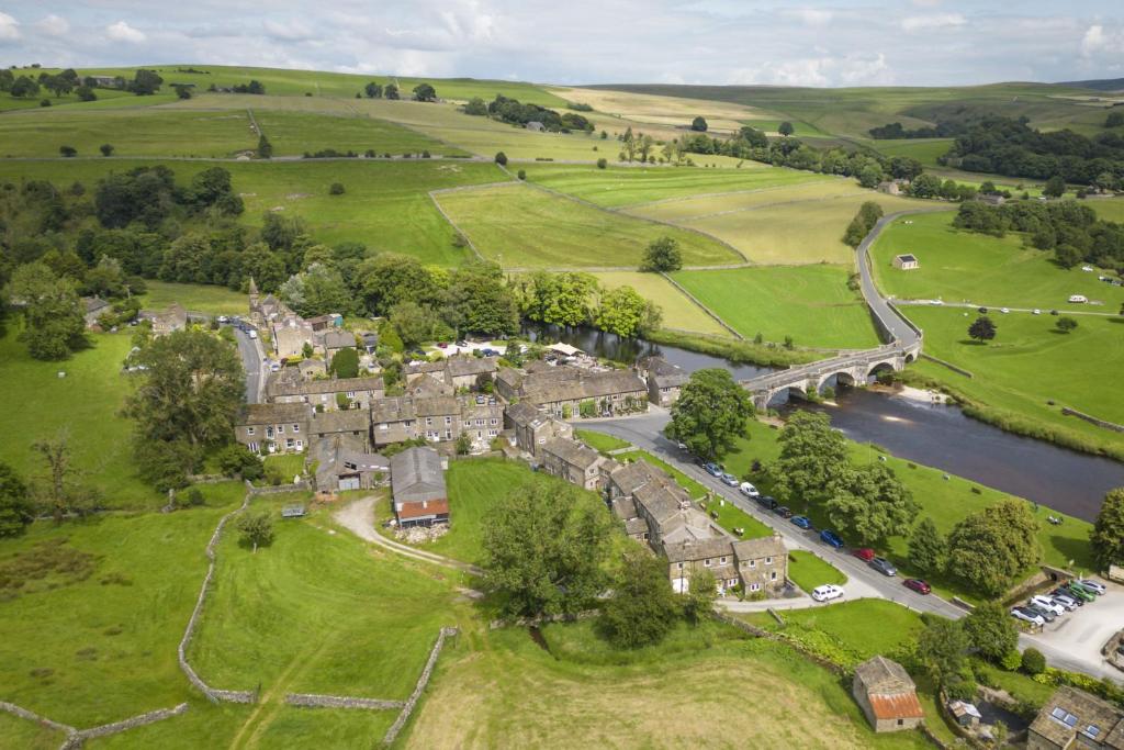 an aerial view of a village with a river at 1 Riverside Cottage in Burnsall