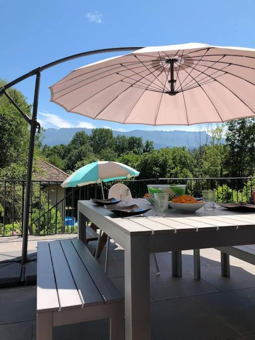 - une table de pique-nique avec un parasol et un banc dans l'établissement Maison de Village Cosy 8 pers - Le Bourget du Lac, au Bourget-du-Lac