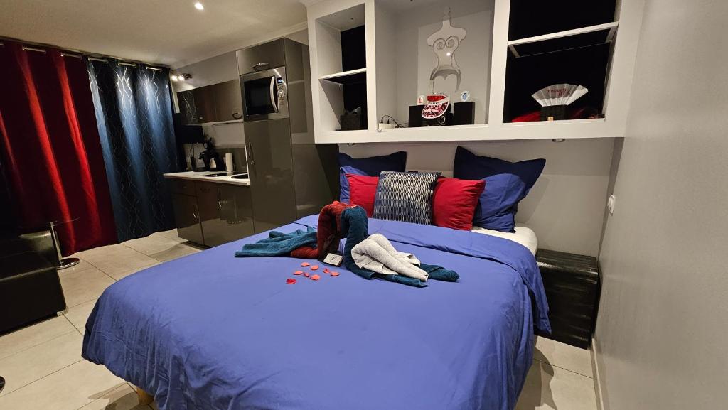 a bedroom with a bed with blue sheets and red pillows at CapSexy Port Nature Marina Naturist Village in Cap d'Agde