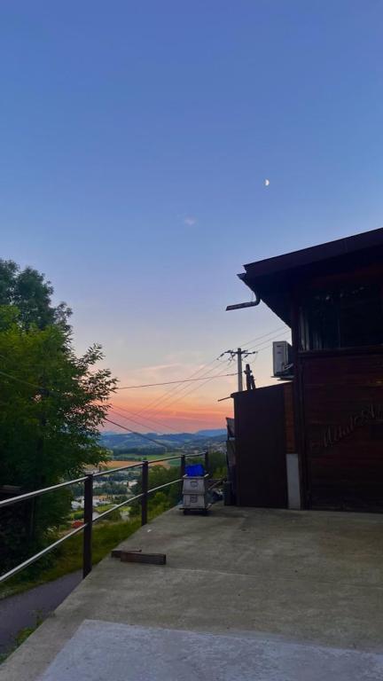un bâtiment avec un coucher de soleil en arrière-plan dans l'établissement Le Bellevue, à Epagny Metz-Tessy