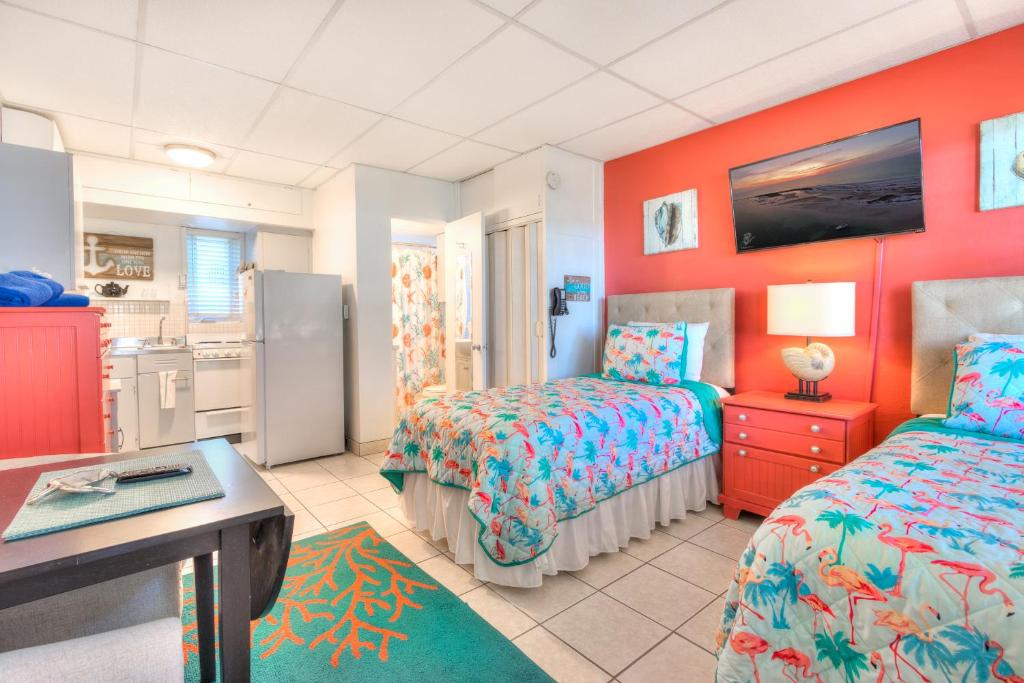 a hotel room with two beds and a kitchen at Tropic Terrace Suite #24 - Beachfront Resort in St Pete Beach
