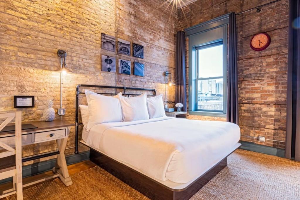 a bedroom with a bed and a desk and a window at Hip Urban Loft - Small Town Charm - 124 LOFTS #4 in West Dundee