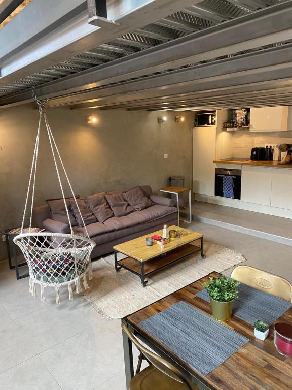 - un salon avec un canapé et une balançoire dans l'établissement Charmant Loft Moderne à 10min de la Grande Plage, à Biarritz