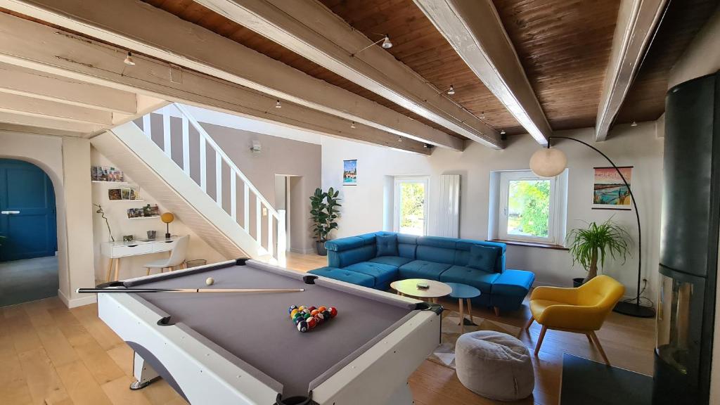 un salon avec une table de billard et un canapé dans l'établissement La Maison du Bord du Lac, à La Chevrolière