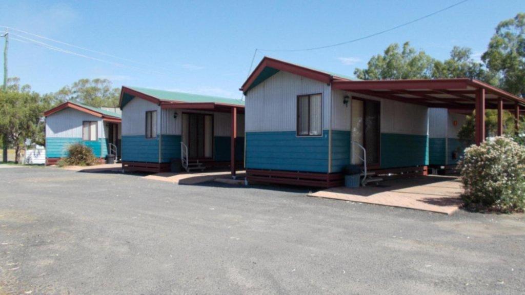 a row of cottages parked in a parking lot at Roma Big Rig Tourist Park in Roma