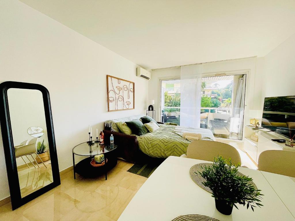 un salon avec un canapé et un miroir dans l'établissement Appartement 2 pièces à Cannes, à Cannes