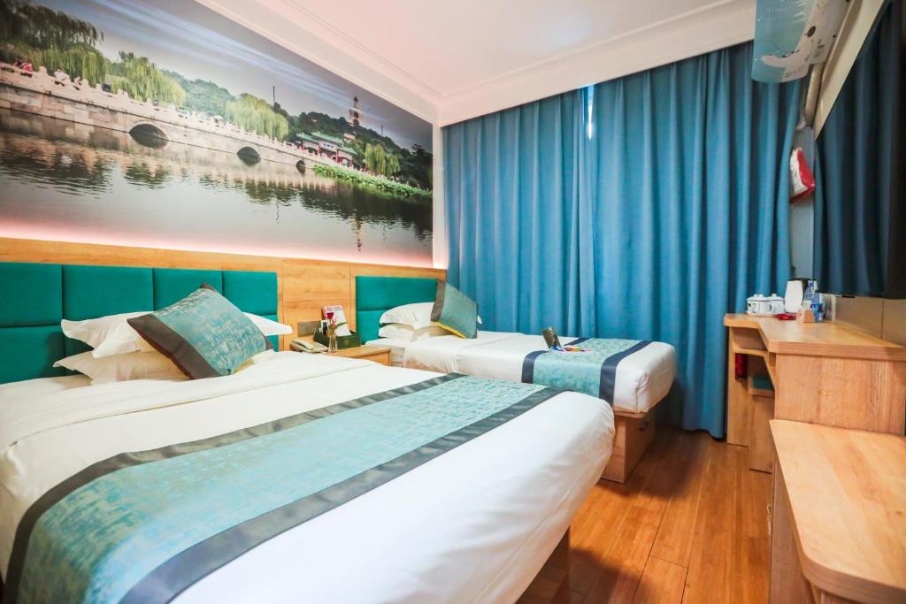 北京市にあるZhong An Hotel Beijing Former Residence of Journalist Edgar Snow -Free laundry service,Free freshly ground coffee,Provide tourism and ticketing service ,English service ,Near Tian'AnMen Forbidden City,Wangfujing walking streetのブルーカーテン付きのホテルルーム内のベッド2台