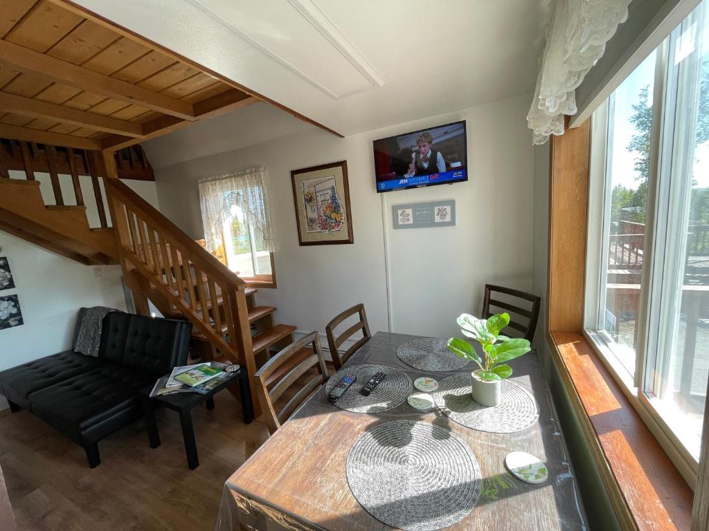 - un salon avec une table à manger et un escalier dans l'établissement Peaceful Acres Cabin 3 - Soldotna, AK, à Kasilof