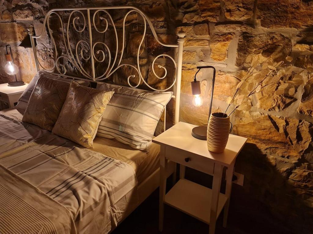 una camera da letto con un letto e un tavolo con una lampada di Casa Villanova ROMANCE a Sečovlje