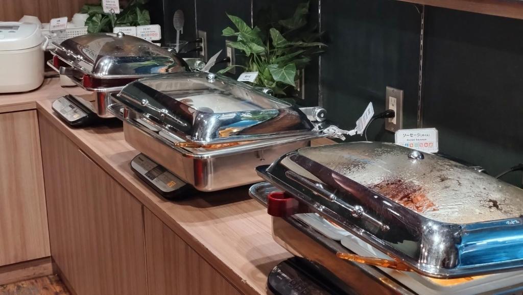a buffet line with several pans on a counter at Henn na Hotel Tokyo Akasaka in Tokyo
